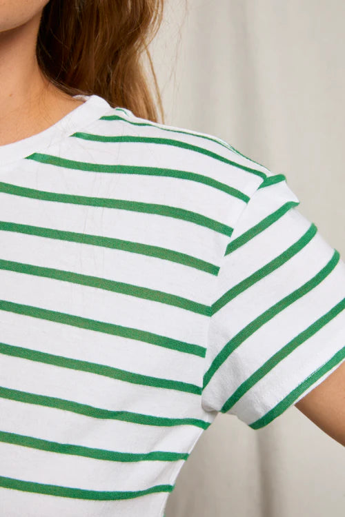 Close-up of a person wearing a white t-shirt with green stripes.