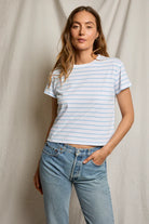 Woman wearing a striped t-shirt and jeans against a plain background