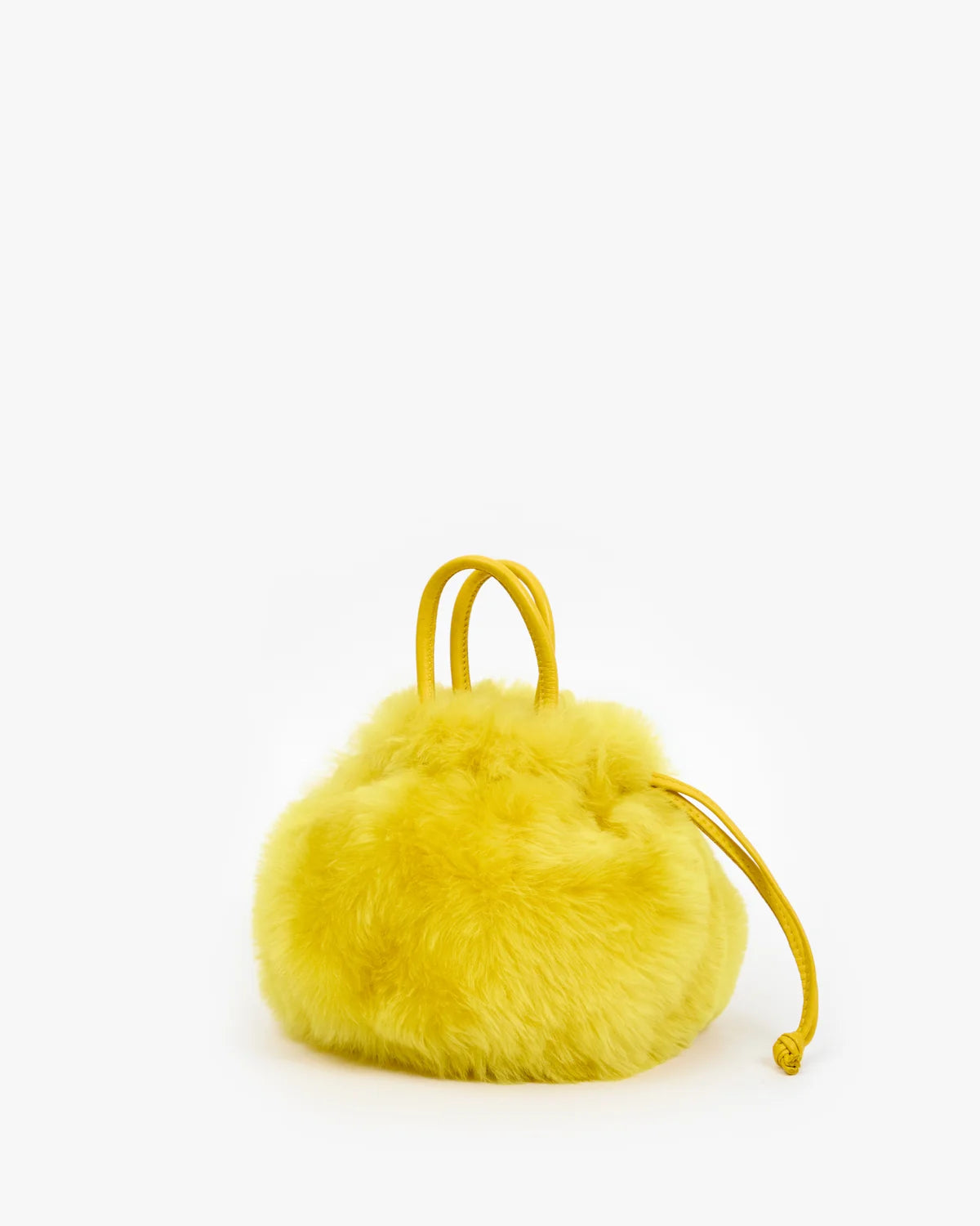 A small fluffy yellow faux-fur drawstring pouch bag with two short handles, photographed on a clean white background.