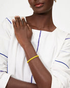 Person wearing a yellow bracelet on a white background