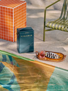 Blue Fieldbar cooler by a poolside with a tray of drinks and snacks.