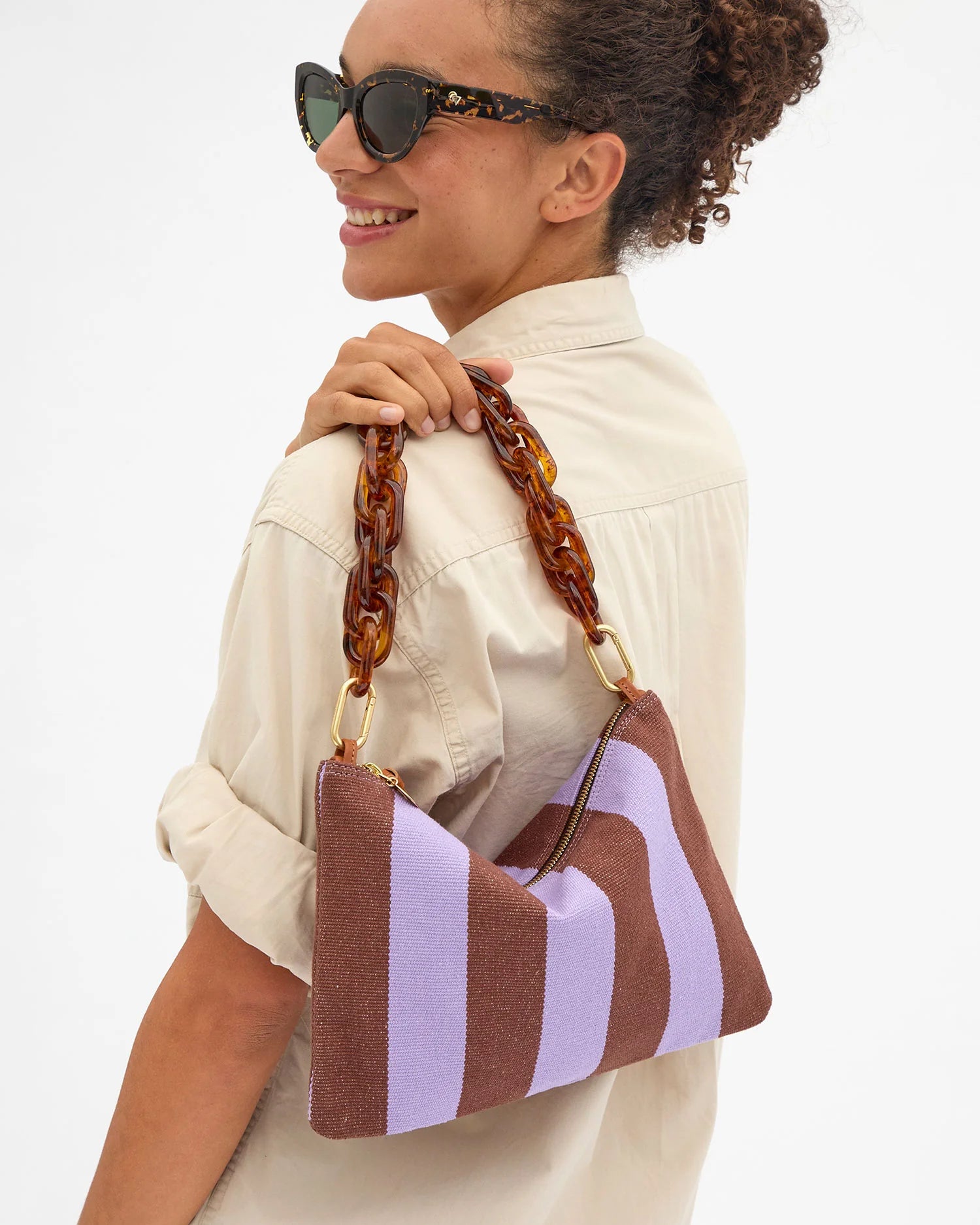 Woman holding a striped handbag with a white background