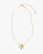Necklace with gold chain, blue pendant, and leaf charm on a white background
