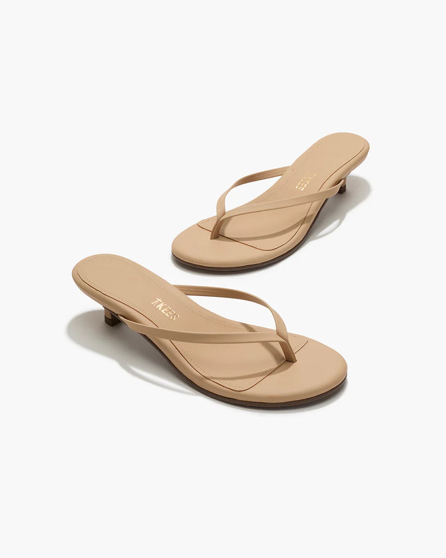 Pair of beige high-heeled sandals on a white background
