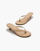 Pair of beige high-heeled sandals on a white background