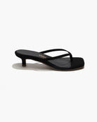 Black sandal with thin strap on a white background