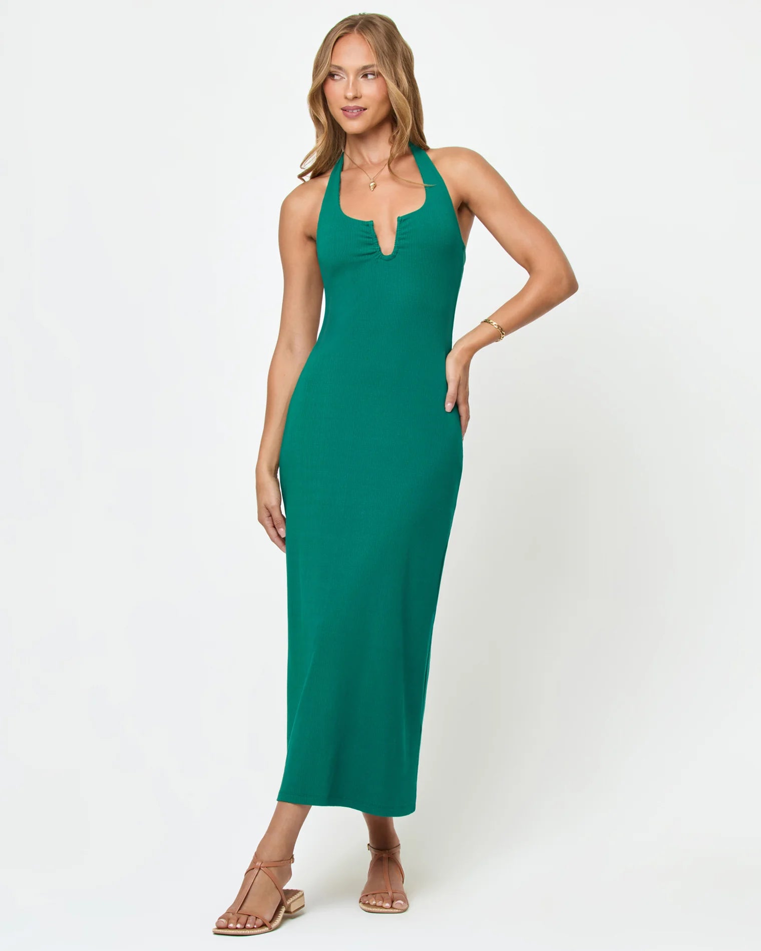 Woman wearing a green halter neck dress on a white background