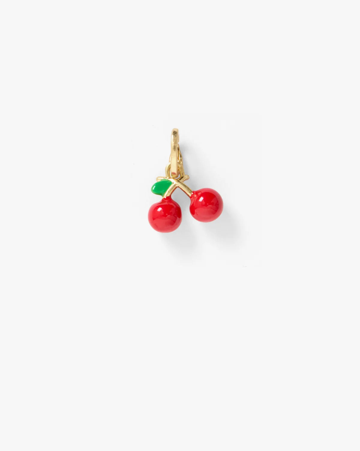 A pair of gold hoop earrings featuring small cherry charms with glossy red enamel bodies and green enamel leaves, set against a plain light gray background.