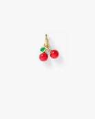 A pair of gold hoop earrings featuring small cherry charms with glossy red enamel bodies and green enamel leaves, set against a plain light gray background.