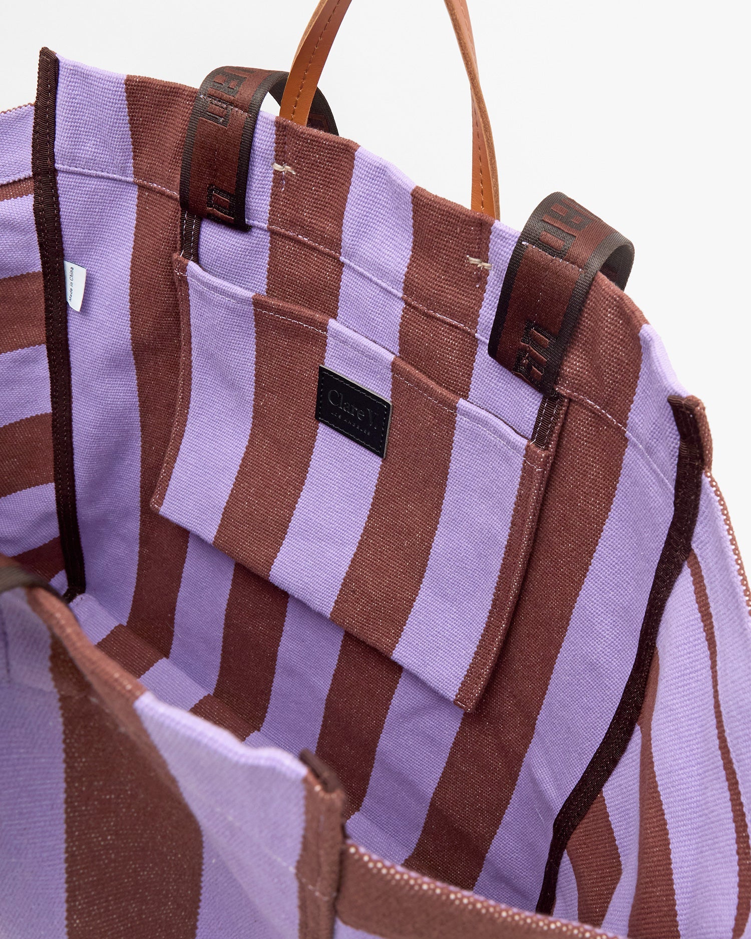 Purple and brown striped tote bag with visible brand label on a white background