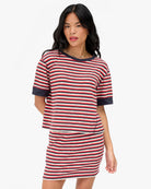 Woman wearing a red and white striped dress on a white background
