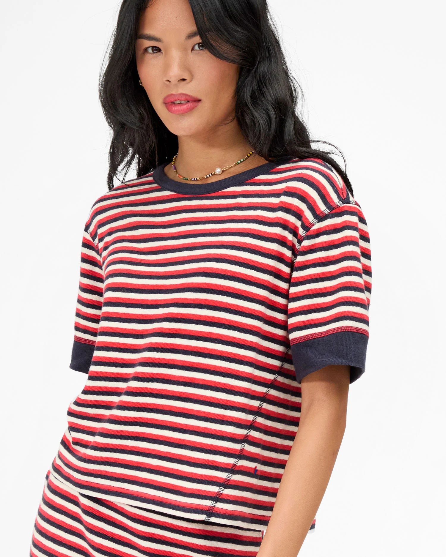 Woman wearing a red, white, and blue striped shirt on a white background
