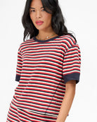 Woman wearing a red, white, and blue striped shirt on a white background
