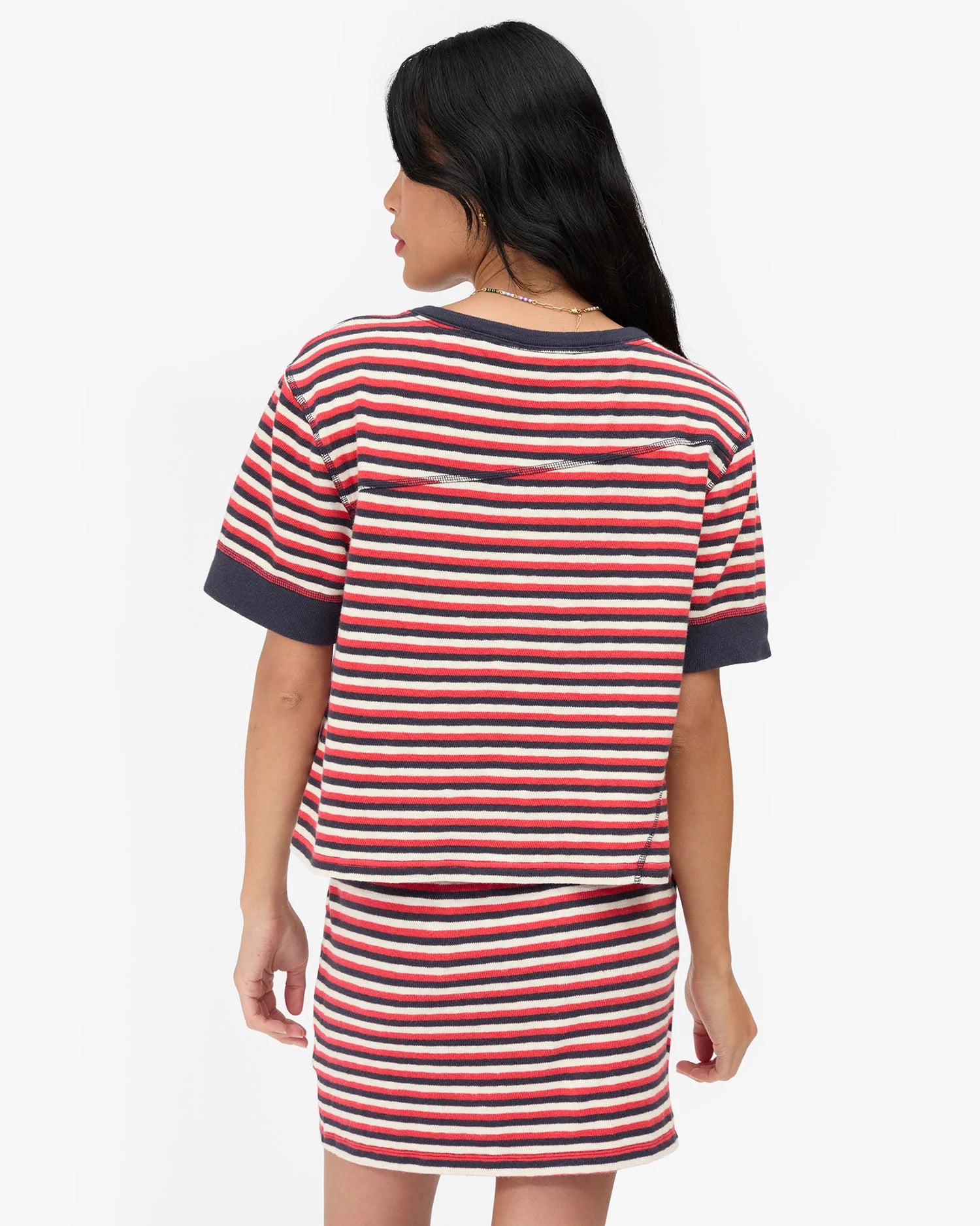 Woman wearing a red and white striped dress on a white background