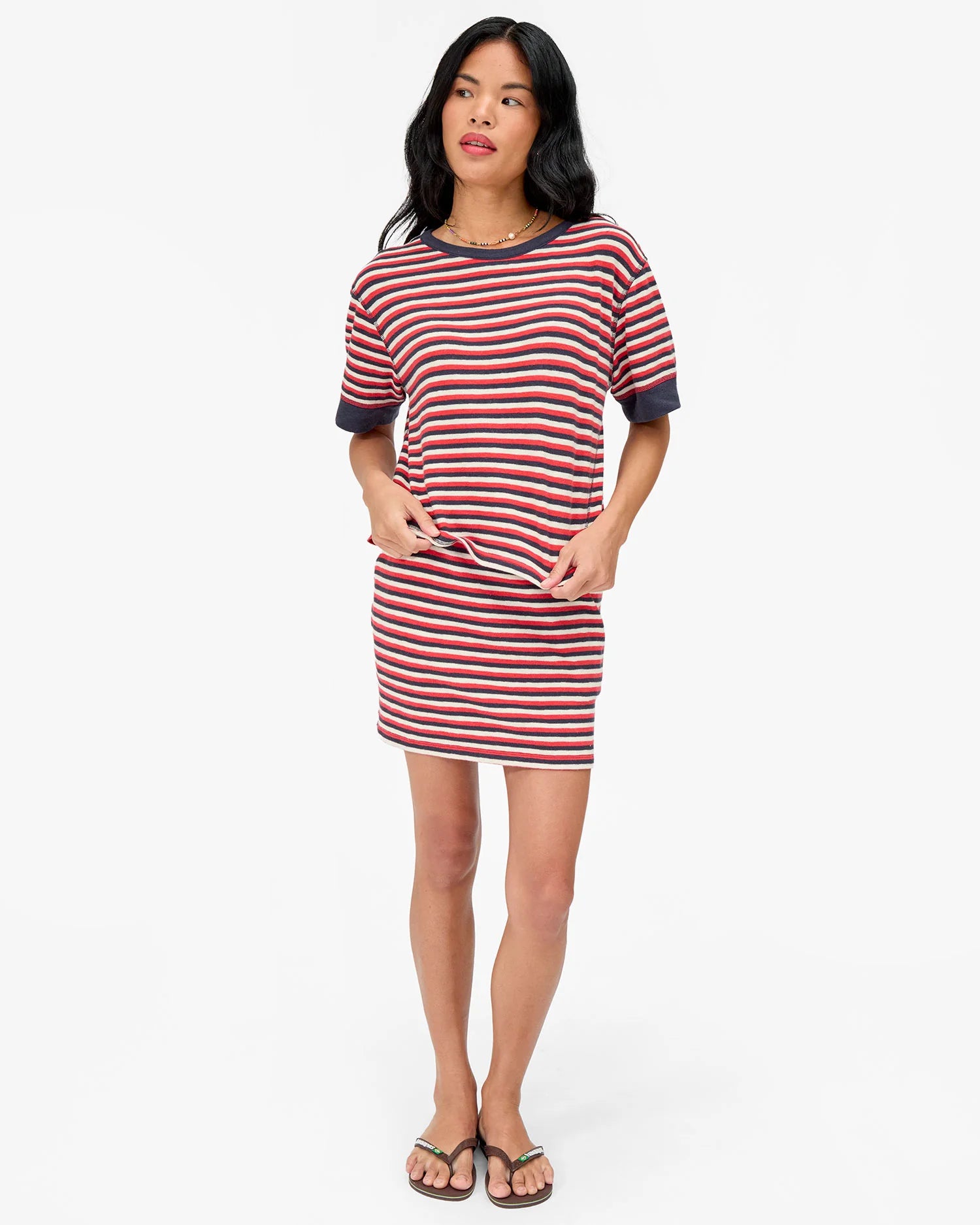 Woman wearing a red and white striped dress on a white background