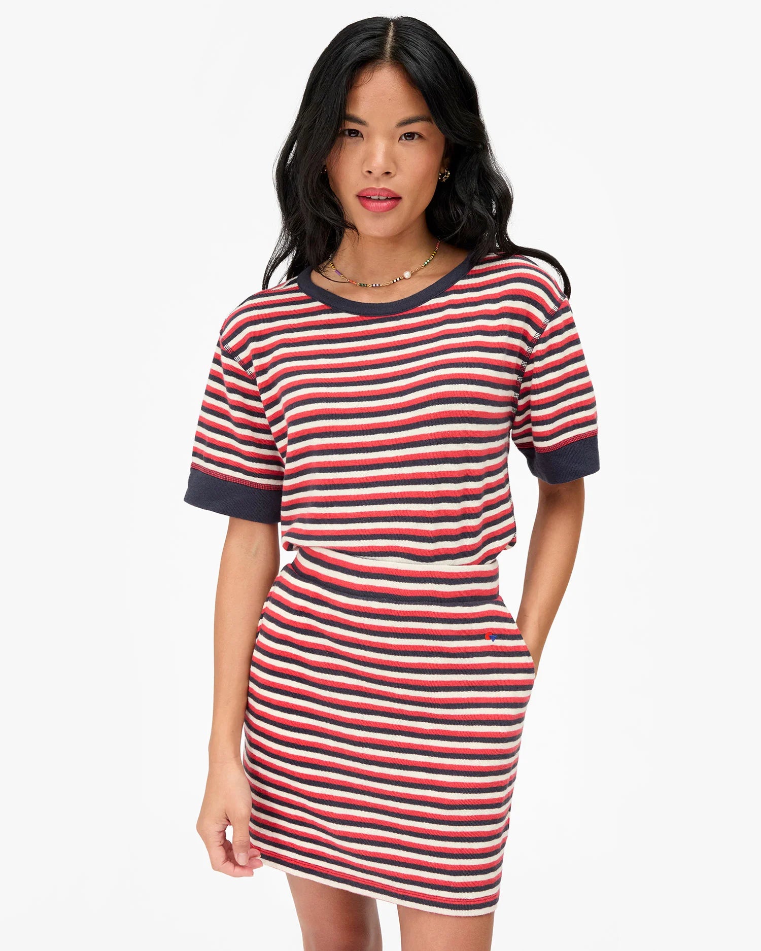 Woman wearing a red and white striped dress on a white background