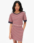 Woman wearing a red and white striped dress on a white background
