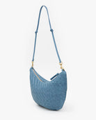 Blue woven handbag with a strap on a white background