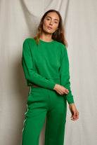 Woman wearing a green outfit against a neutral background