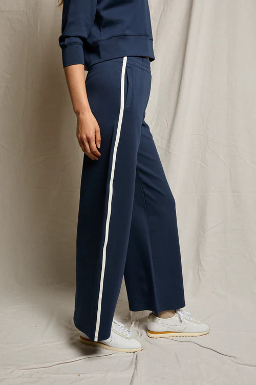 Navy tracksuit with white stripes on a neutral background