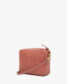 Pink woven handbag on a white background