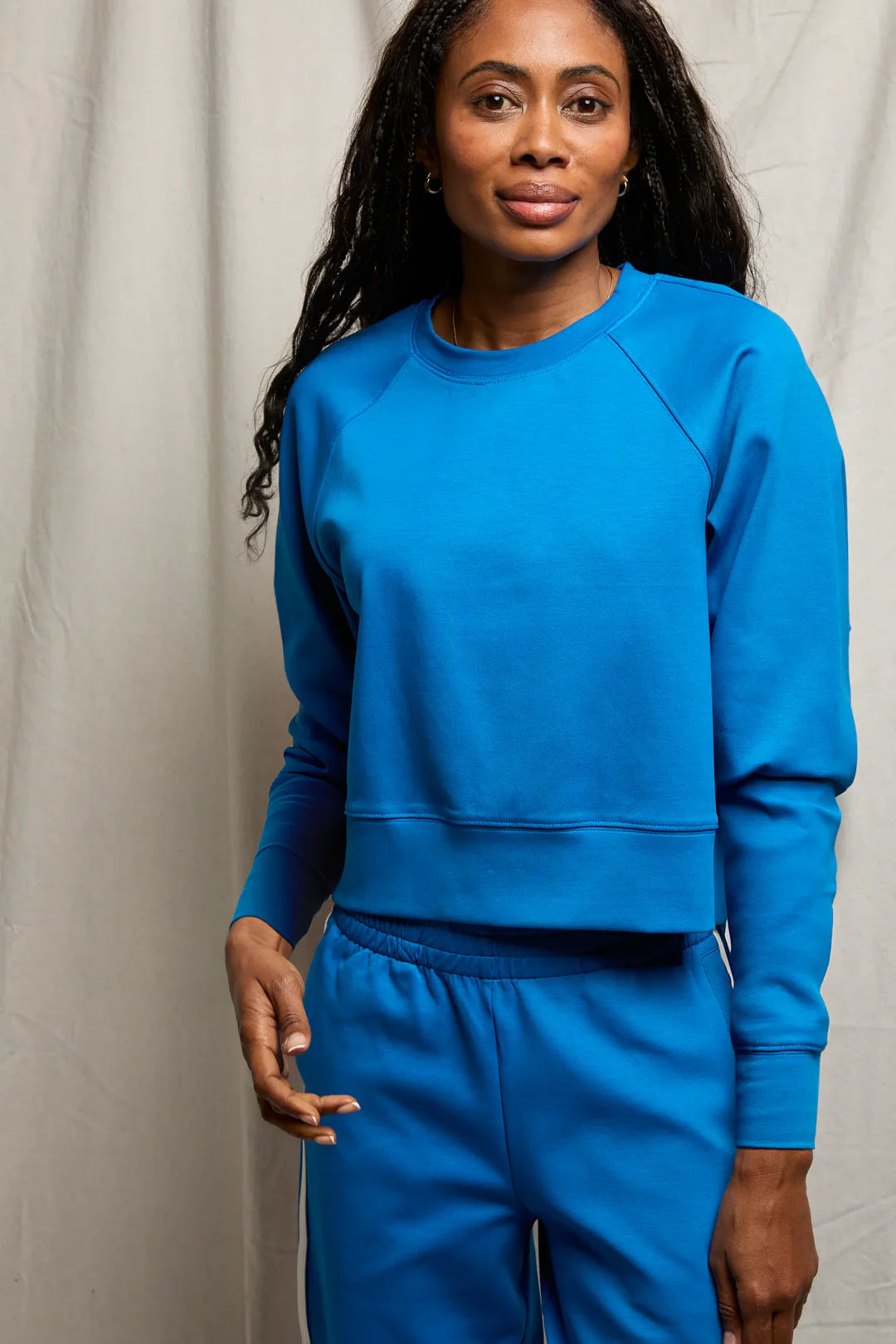 Woman wearing a blue tracksuit against a plain background