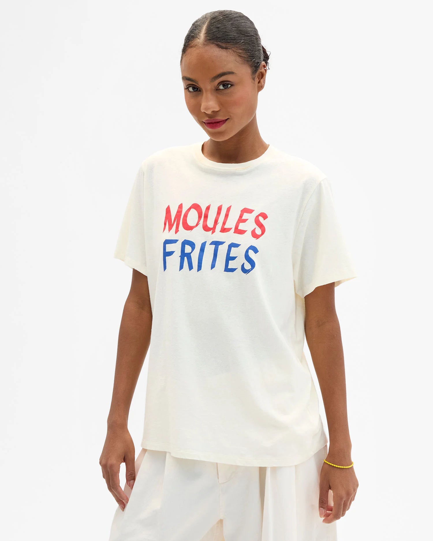 Woman wearing a white t-shirt with 'MOULES FRIITES' text on a white background