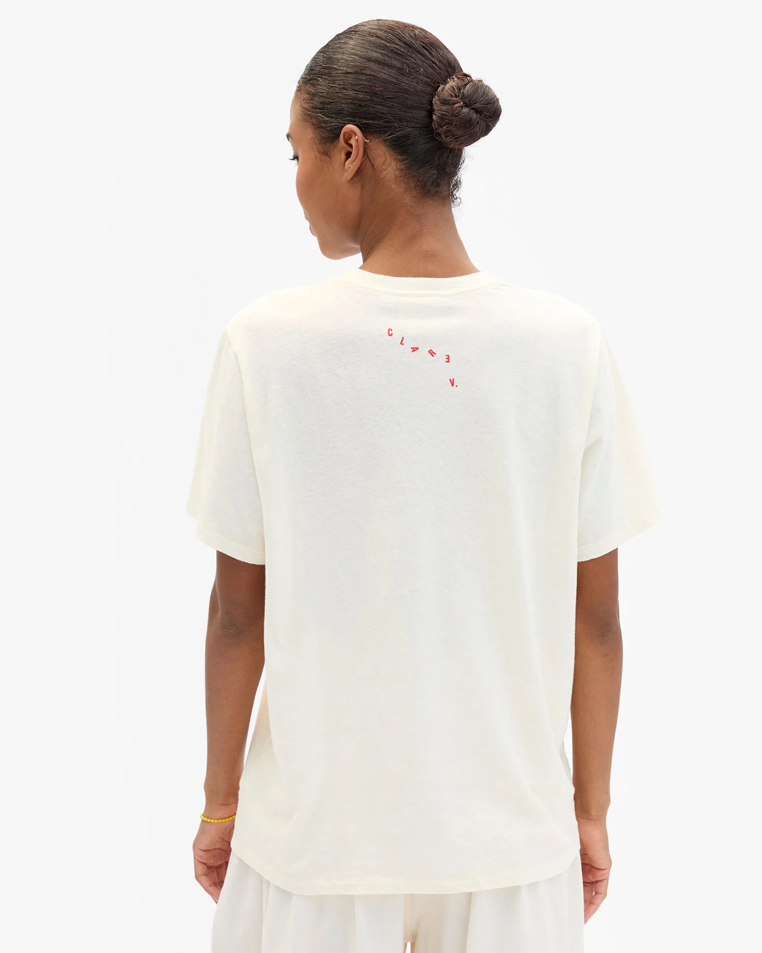 Person wearing a white t-shirt with text on the back against a white background