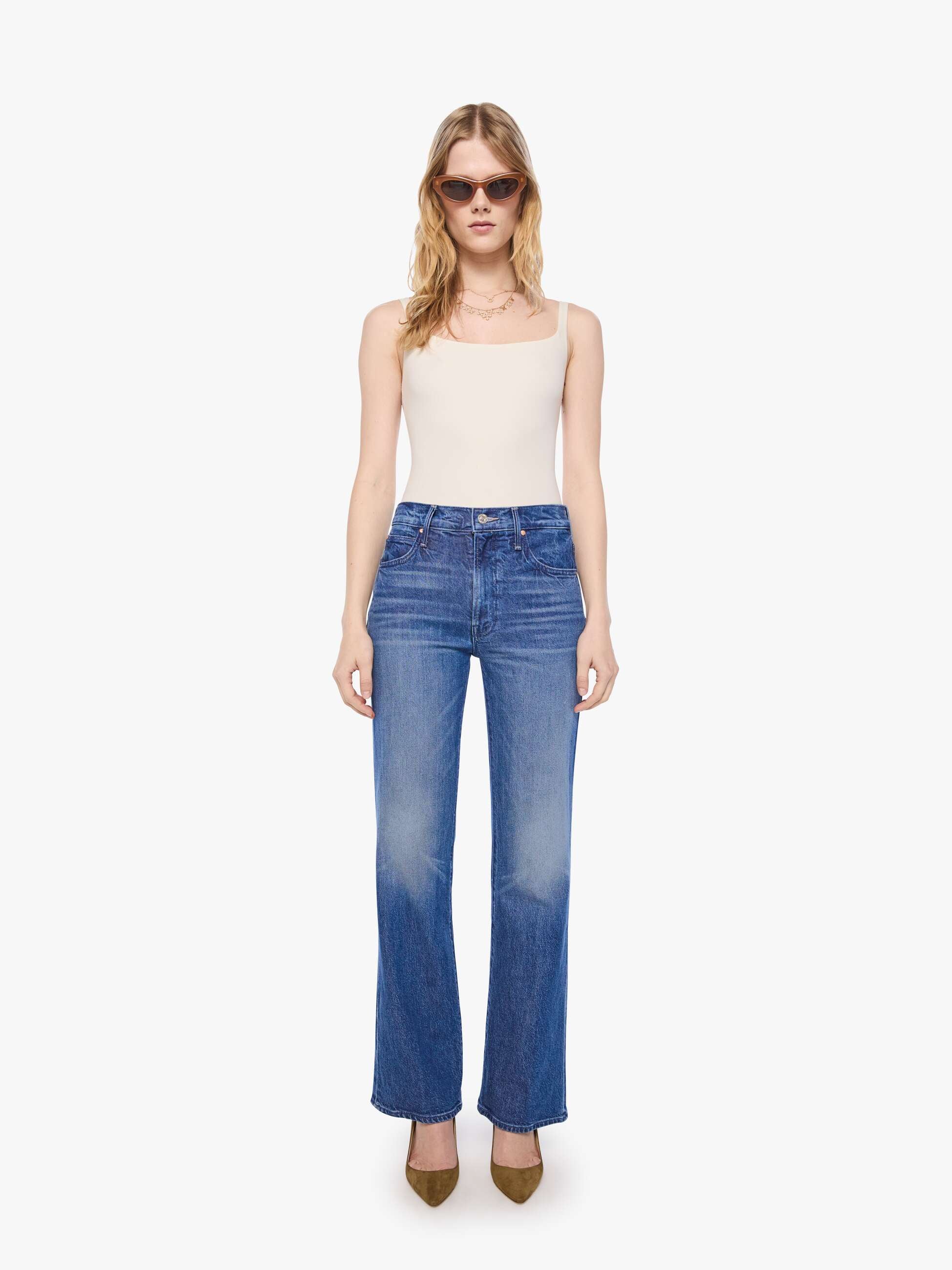 Woman wearing blue jeans and a white top on a white background
