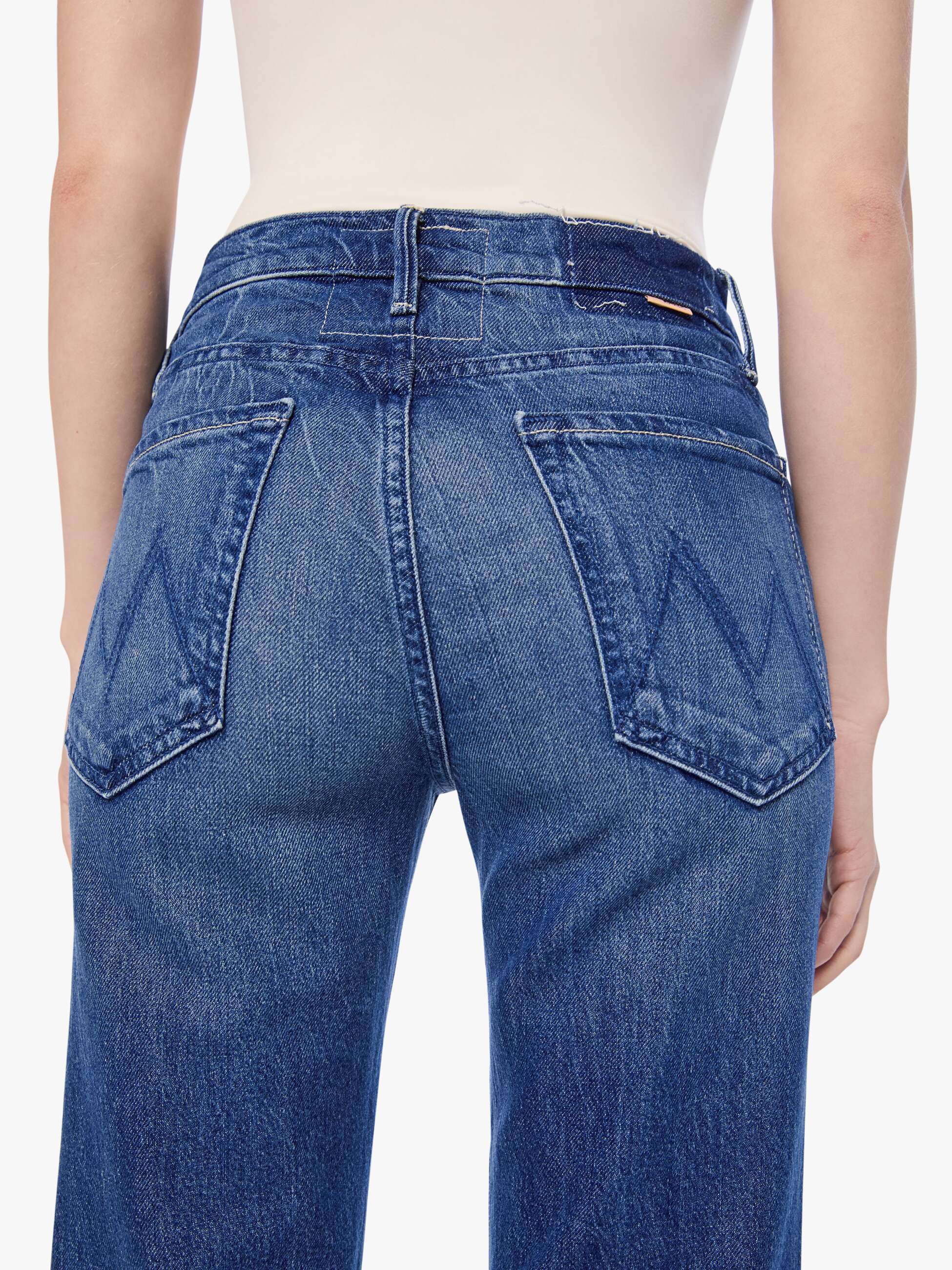 Blue jeans worn by a person on a white background