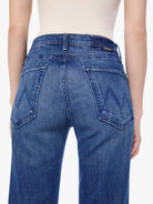 Blue jeans worn by a person on a white background