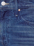 Close-up of blue denim fabric with button and stitching details