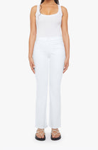 Person wearing a white sleeveless top and pants on a white background