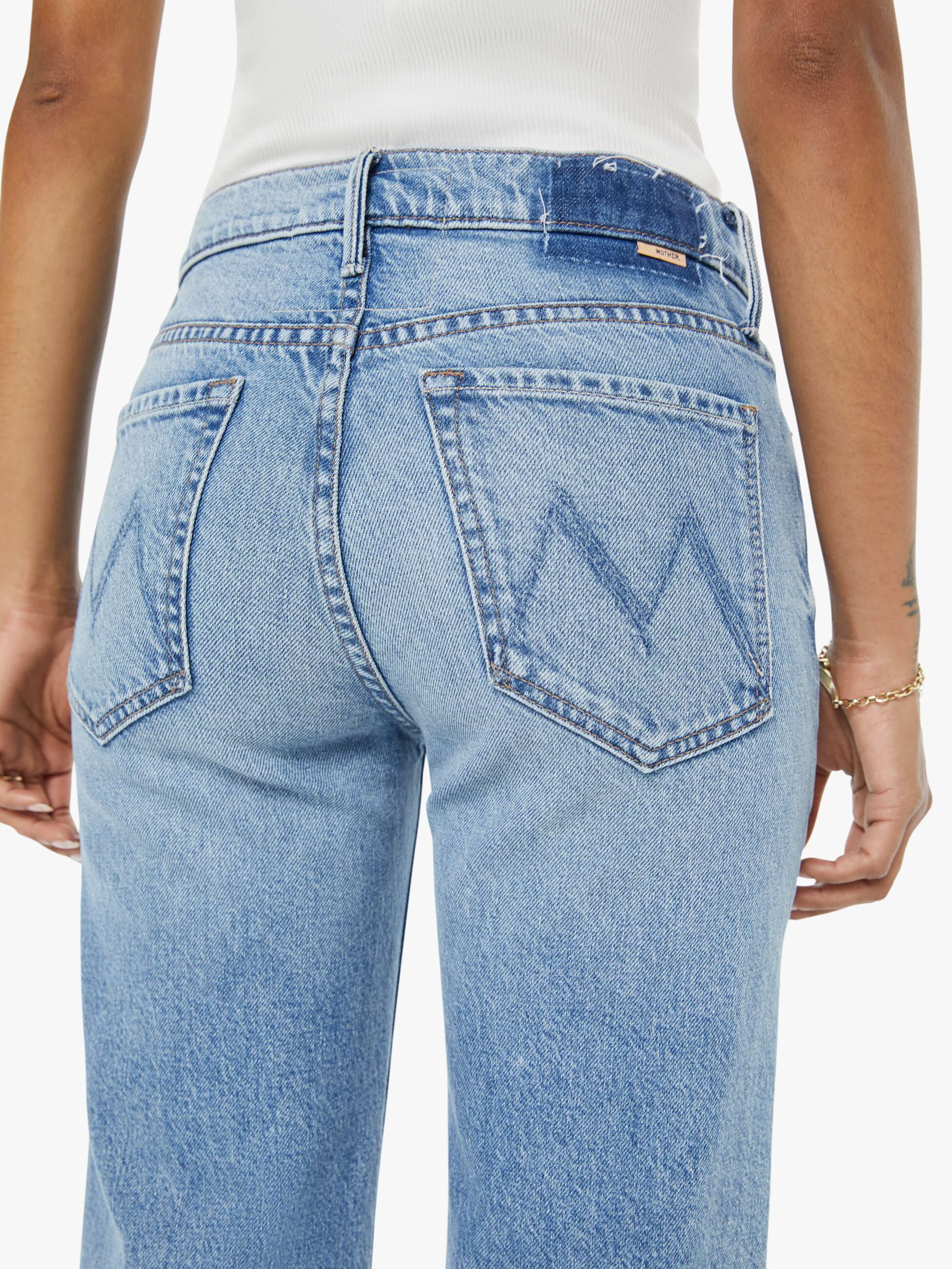 Light blue jeans worn by a person, showing the back pocket design.