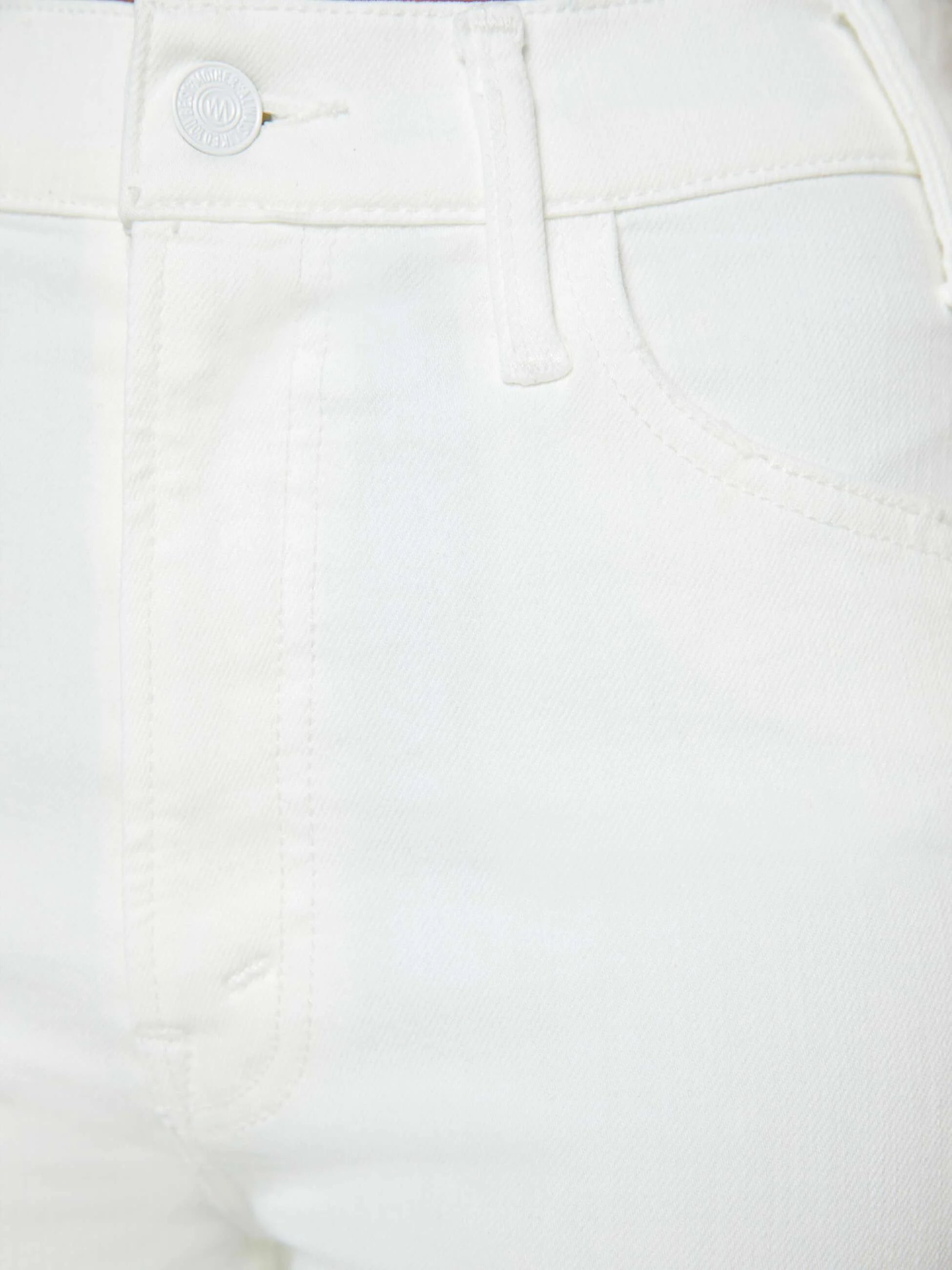Close-up of a white denim fabric with a button and stitching detail.