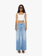 Woman wearing a white top and blue jeans on a white background