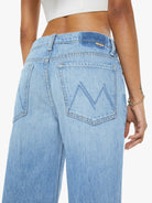 Light blue jeans with a brand logo on the back pocket against a white background