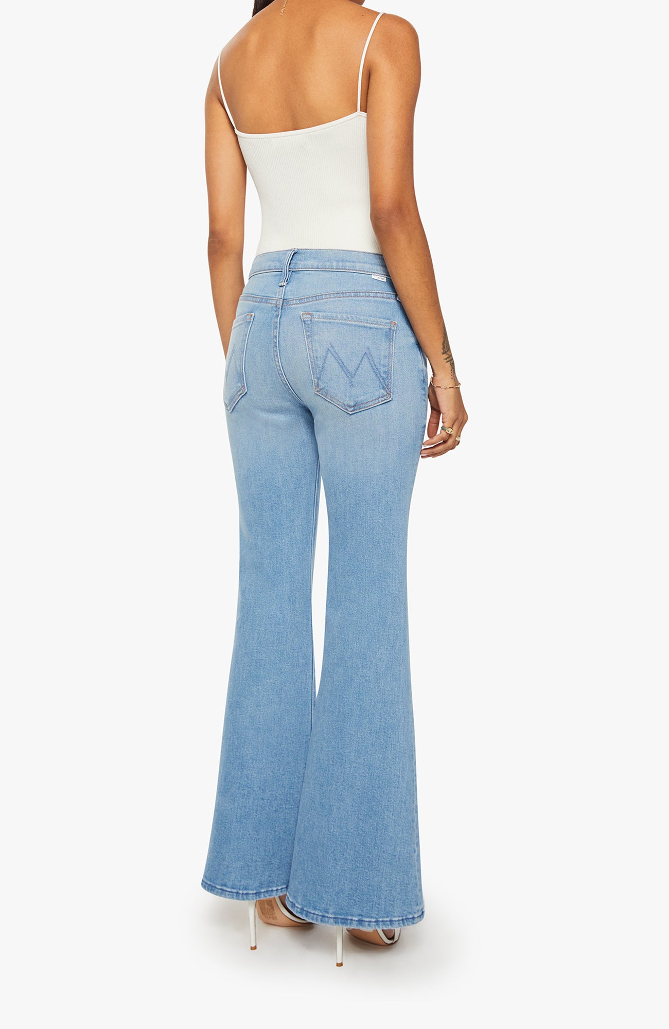 Light blue flared jeans worn by a person on a white background