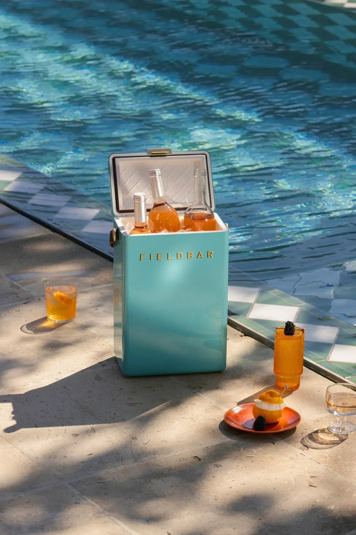 Turquoise cooler with drinks by a poolside