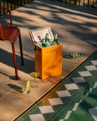 Orange cooler box with drinks by a poolside