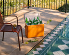 Orange cooler box with drinks by a poolside on a patio