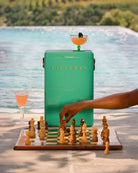 Green 'FIELDBAR' cooler with a chessboard and drinks by a poolside