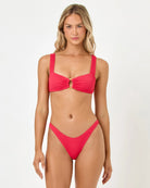 Woman wearing a pink bikini against a white background