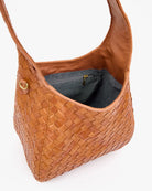 Brown woven handbag with a gold clasp on a white background