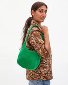 Woman holding a green handbag against a white background