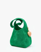 Green handbag with a heart-shaped charm on a white background