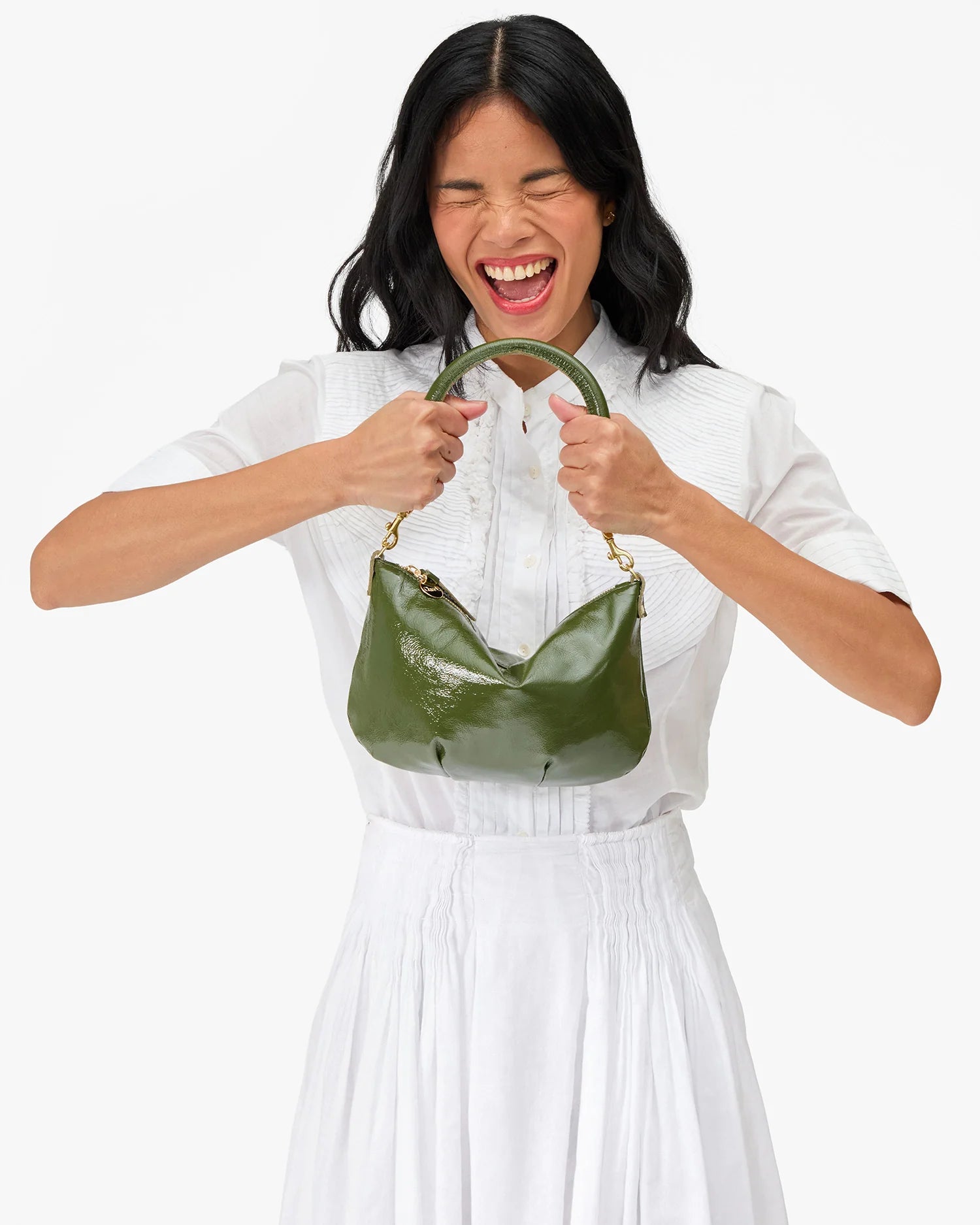 Woman holding a green handbag against a white background