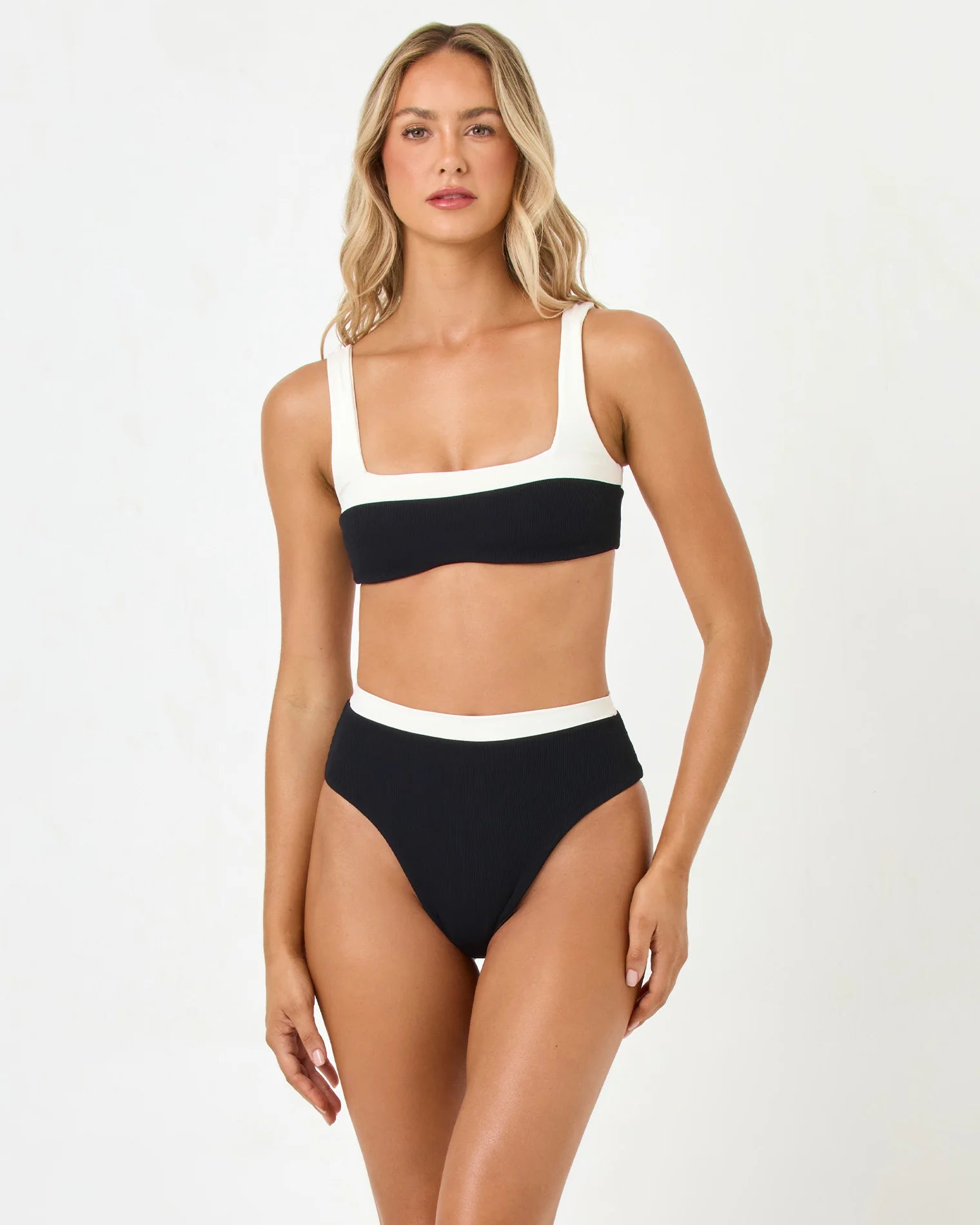 Woman wearing a black and white bikini set on a white background