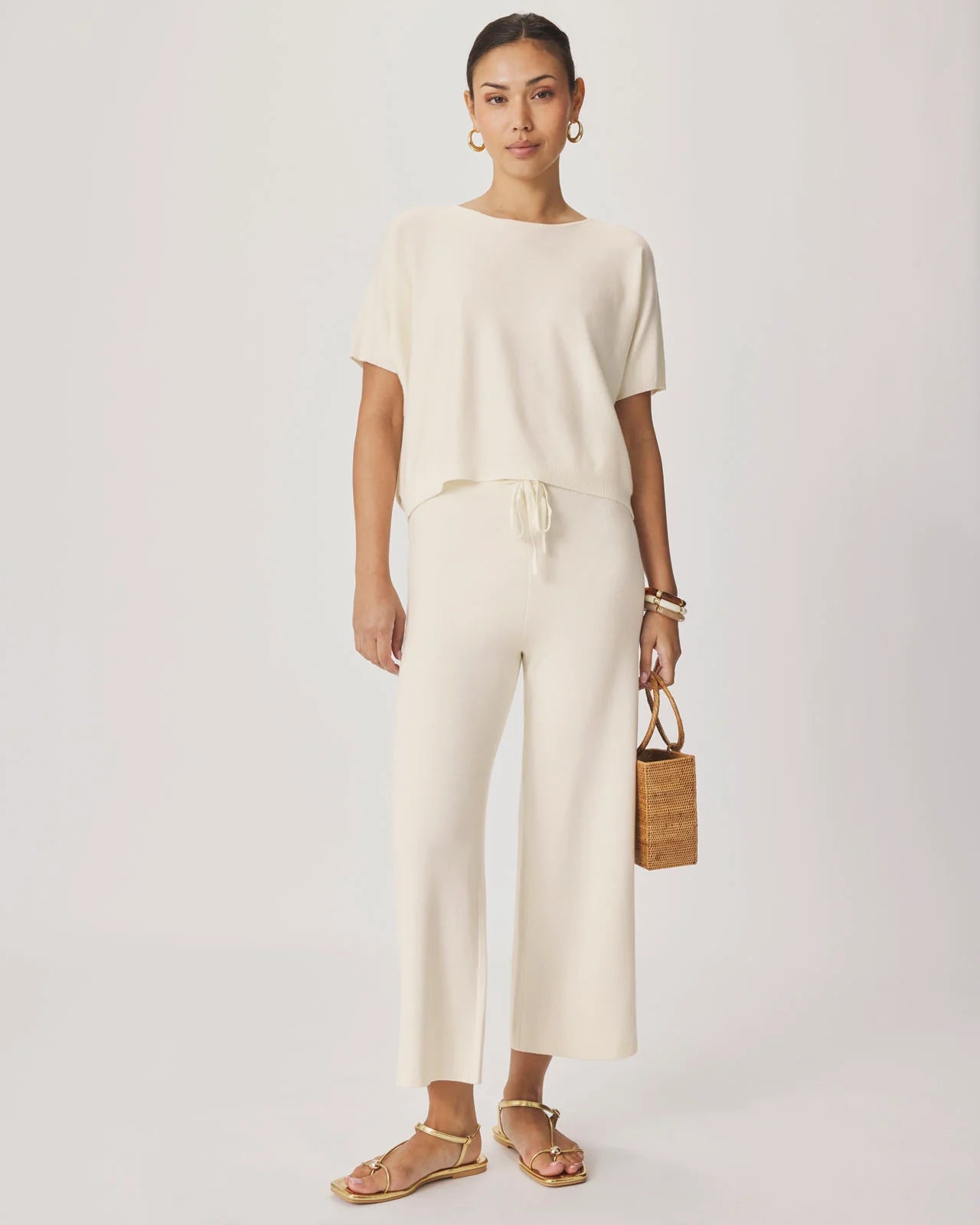 Woman wearing a beige outfit with a plain background