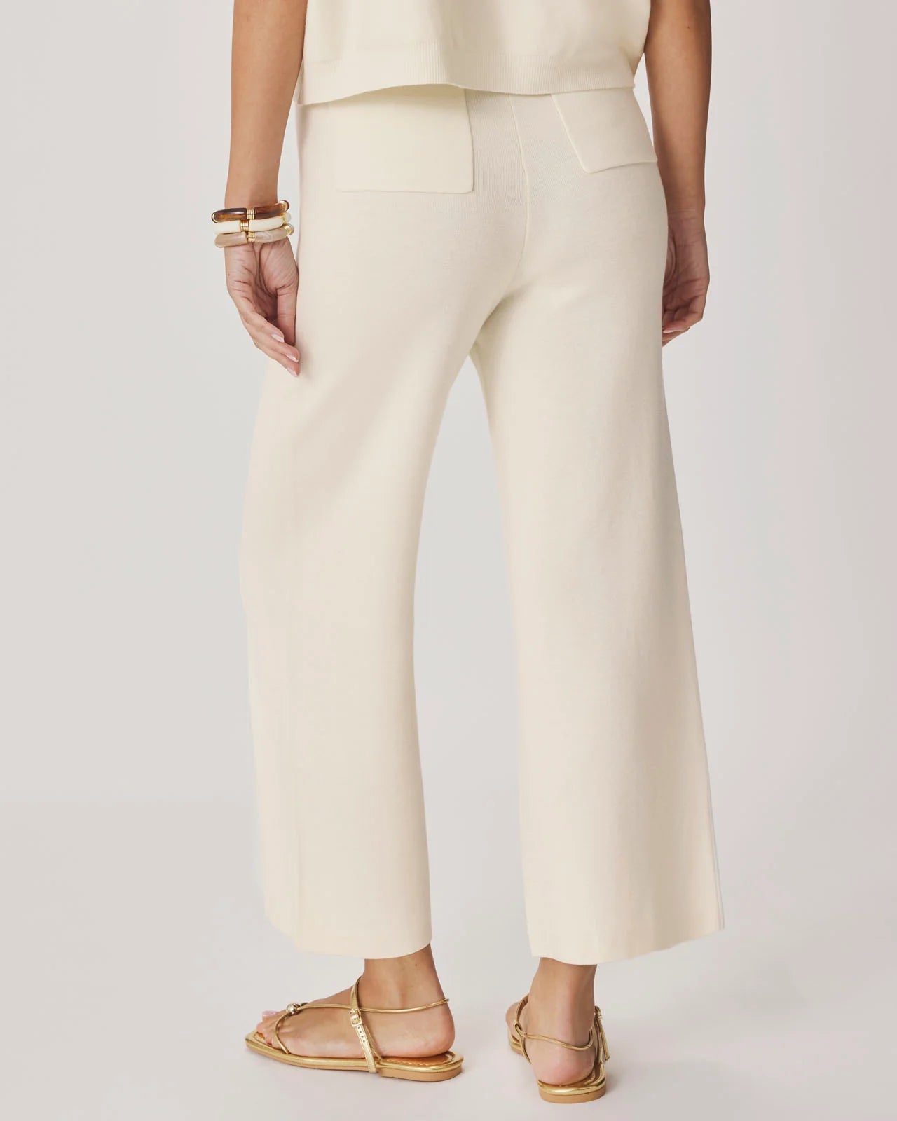 Person wearing cream-colored pants on a plain background